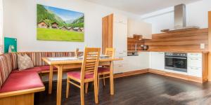 uma cozinha e sala de jantar com uma mesa e um sofá em Apartment Schlickenhof em Hintergöriach