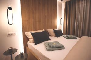 a bed with black and white pillows on it at TOP Room in Šabac