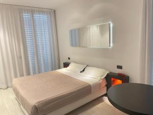 a bedroom with a bed with a table and a mirror at Blue Shades ApartHotel in Pisa
