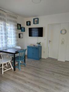 une salle à manger avec une table et un meuble bleu dans l'établissement Apartman Alka, à Žaborić