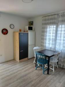 La cuisine est équipée d'une table, de chaises et d'un réfrigérateur. dans l'établissement Apartman Alka, à Žaborić