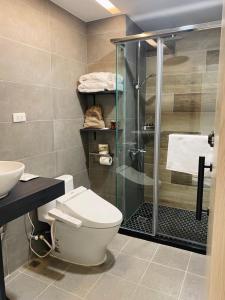 a bathroom with a toilet and a glass shower at Daybyday Moon Homestay in Yuchi