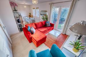 a living room with a red couch and blue chairs at Blue Cedar 2 Bed, 2 Bath Apt with Parking, Birmingham by 360Midlands in Sutton Coldfield