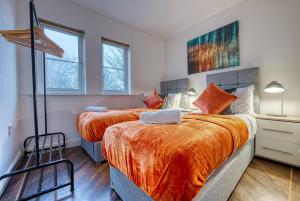 - une chambre avec 2 lits avec des draps orange dans l'établissement Blue Cedar 2 Bed, 2 Bath Apt with Parking, Birmingham by 360Midlands, à Sutton Coldfield