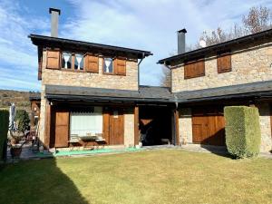ein großes Backsteinhaus mit großem Hof in der Unterkunft Casa Riu in Riu de Cerdanya