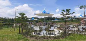 a group of tables and chairs with umbrellas at The Valley Guesthouse in Malang