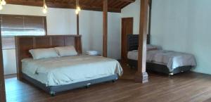 1 dormitorio con 2 camas en una habitación en Joglo Kumpul Resort, en Cangkiran