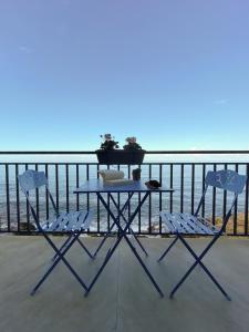 uma mesa e 2 cadeiras numa varanda com vista para o oceano em Terrazza Roberto em Cefalù