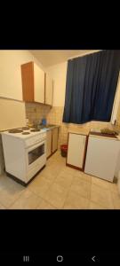 a kitchen with a white stove top oven next to a window at Kamenovo sea in Budva