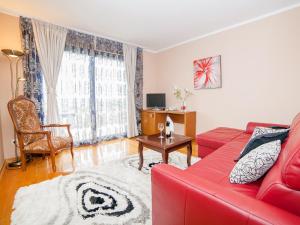 ein Wohnzimmer mit einem roten Sofa und einem Tisch in der Unterkunft Hotel Petrovac in Petrovac na Moru