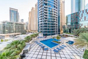an aerial view of a resort with a pool and chairs at Maison Privee - Stunning Apartment with Dubai Marina View in Dubai