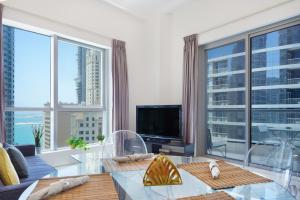 a living room with a large window at Maison Privee - Stunning Apartment with Dubai Marina View in Dubai