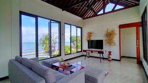 a living room with a view of the ocean at The Grand Villandra Resort in Lovina