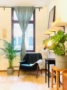 a living room with a chair and a window at (PLANTROOM9)Ganze Wohnung allein in Halle an der Saale