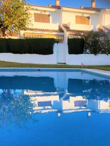 una piscina con una casa en el fondo en HOSTEL ALOHA a 3 calles del Mar, en Sant Salvador