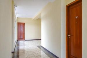 an empty hallway with a door and a tile floor at De Malang Sweet Homestay Syariah Mitra RedDoorz in Malang