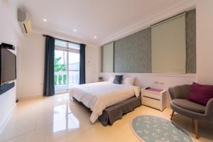 a bedroom with a bed and a couch and a tv at Romatic Venice Homestay in Luodong