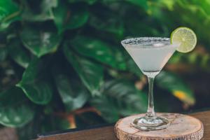 a cocktail glass with a lime on a wooden coaster at Chill Inn Lipa Noi Hostel and Beach Cafe in Koh Samui 