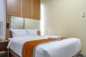 Tempat tidur dalam kamar di De Malang Sweet Homestay Syariah Mitra RedDoorz