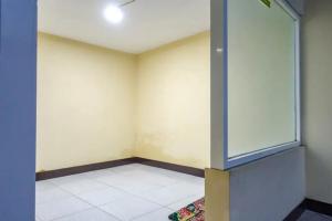 une pièce vide avec une fenêtre en verre sur le mur dans l'établissement De Malang Sweet Homestay Syariah Mitra RedDoorz, à Malang