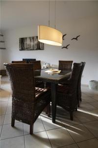 a dining room with a table and wicker chairs at Ferienwohnung Espenau in Espenau