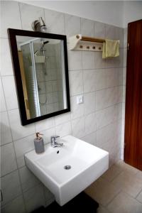 a bathroom with a white sink and a mirror at Ferienwohnung Espenau in Espenau