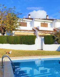 una casa con piscina frente a una casa en HOSTEL ALOHA a 3 calles del Mar, en Sant Salvador