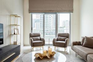 a living room with two chairs and a table at Boutique Living - Marina Wharf in Dubai