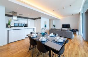 een eetkamer en een woonkamer met een tafel en stoelen bij Maison Privee - Stunning Sea Views on Dubai's New Luxury Island in Dubai