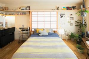 1 dormitorio con 1 cama grande con alfombra a rayas en PDO INN Coffee & Open-air bath on the roof, en Tokio