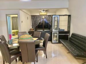 a dining room and living room with a table and chairs at Homestay Legacy Kamariah Ahmad,Lumut in Lumut