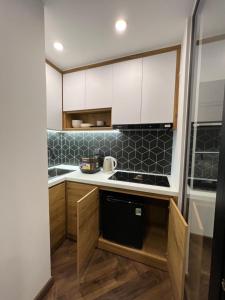 una cucina con armadietti bianchi e lavastoviglie nera di LE CIMENT - Apartment Hotel a Da Lat Altre 39 foto