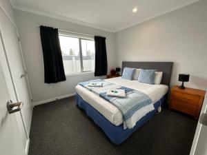 a bedroom with a large bed and a window at Home Away from Home in Napier