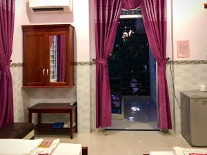 sala de estar con cortinas rojas y puerta en 2001 Motel en Long Hai