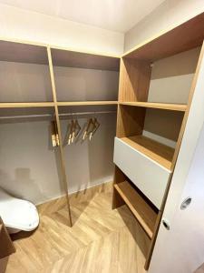 a closet with wooden shelves and a toilet in a room at MOBIL HOME LE LUMINEUX VALRAS in Valras-Plage