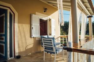 Villa Christa في أريلاز: شرفة مع كرسي هزاز وطاولة