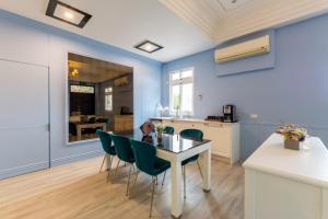 羅東鎮的住宿－曼漫威尼斯，一间厨房和带蓝色墙壁及桌椅的用餐室