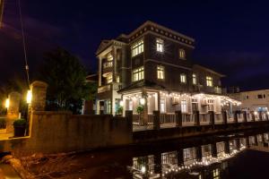 a house with lights on the water at night at Romatic Venice Homestay in Luodong