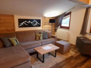 sala de estar con sofá y mesa en Apart Alpen Royal, en Nauders