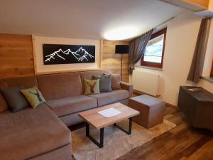 a living room with a couch and a table at Apart Alpen Royal in Nauders