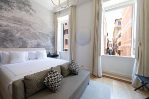 a bedroom with a bed and a couch and a window at Elizabeth Unique Hotel | a Member of Design Hotels™ in Rome