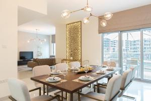 Boutique Living - Marina Wharf في دبي: غرفة طعام مع طاولة وكراسي