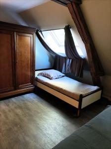 a small bed in a room with a window at Manoir de Bolbec in Bolbec