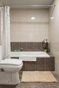 Boutique Living - Marina Wharf في دبي: حمام مع مرحاض وحوض استحمام
