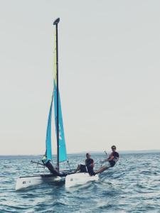 dos hombres están sentados en un velero en el agua en Stellamandra, en Murten