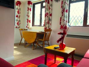 Tovey Lodge في Hassocks: غرفة معيشة مع طاولة و مزهرية مع الزهور فيها