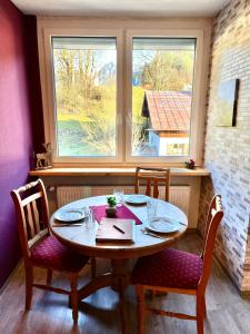 a table and chairs in a room with a window at BERGFEX Falkenberg 202 mit Sommer-Bergbahnticket in Oberstdorf