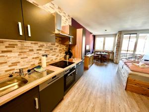 a kitchen with a sink and a couch in a room at BERGFEX Falkenberg 202 mit Sommer-Bergbahnticket in Oberstdorf