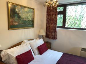 a bedroom with a bed with red and white pillows at Tovey Lodge in Hassocks