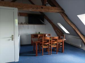 a dining room with a table and chairs and a tv at Manoir de Bolbec in Bolbec